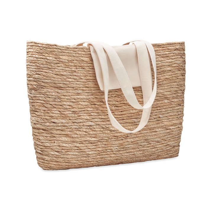A shopping beach bag made from woven cattail leaves, featuring a canvas pocket and straps. - Banbury